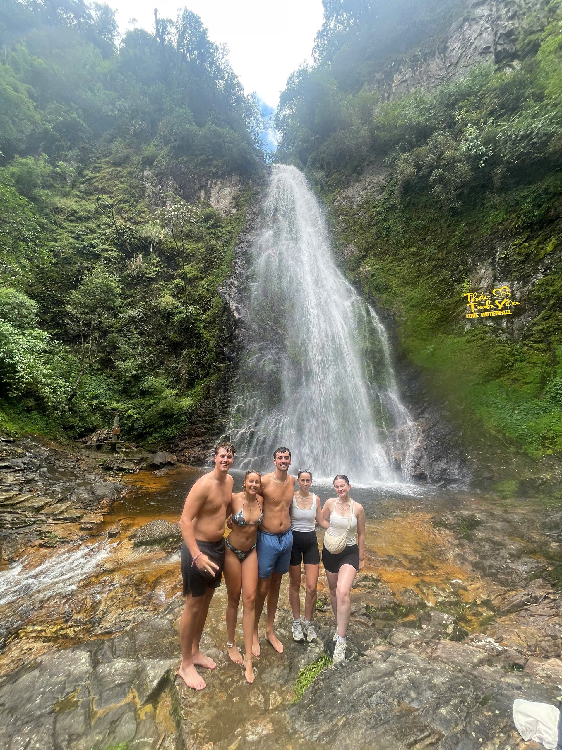 Waterfall surrounded by green forest near O Quy Ho Pass