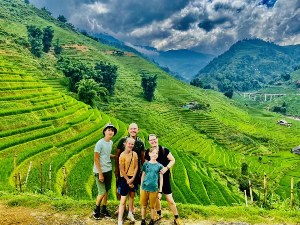 Family group overlooking green rice terraces near Sa Pa