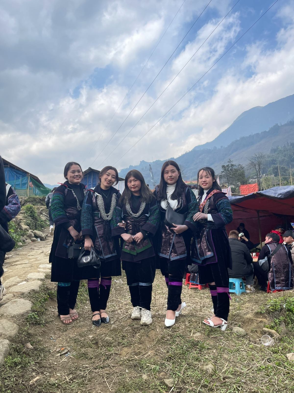 Local women wearing traditional clothing with mountains behind them