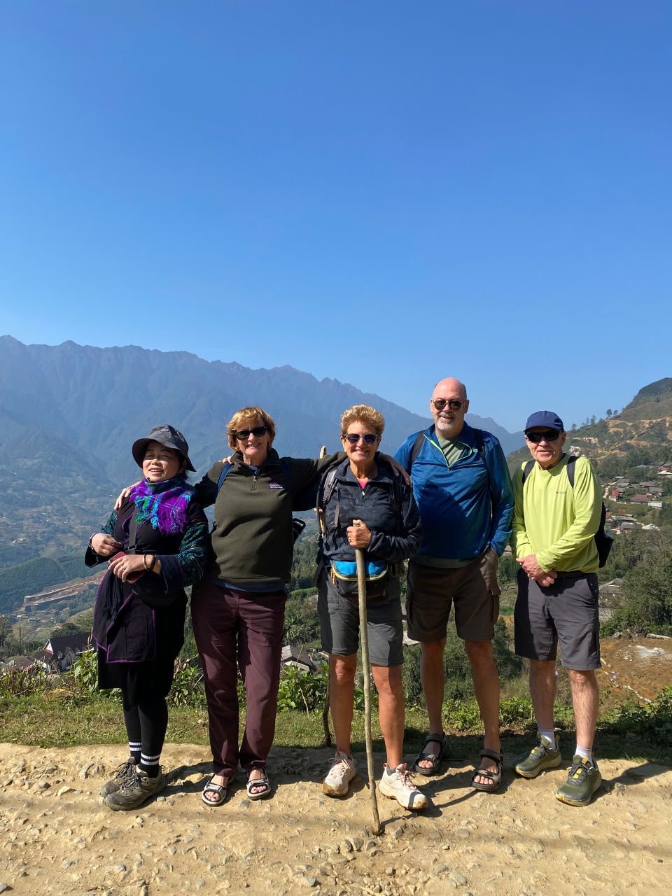 A local guide with hikers on a high mountain path near Sa Pa