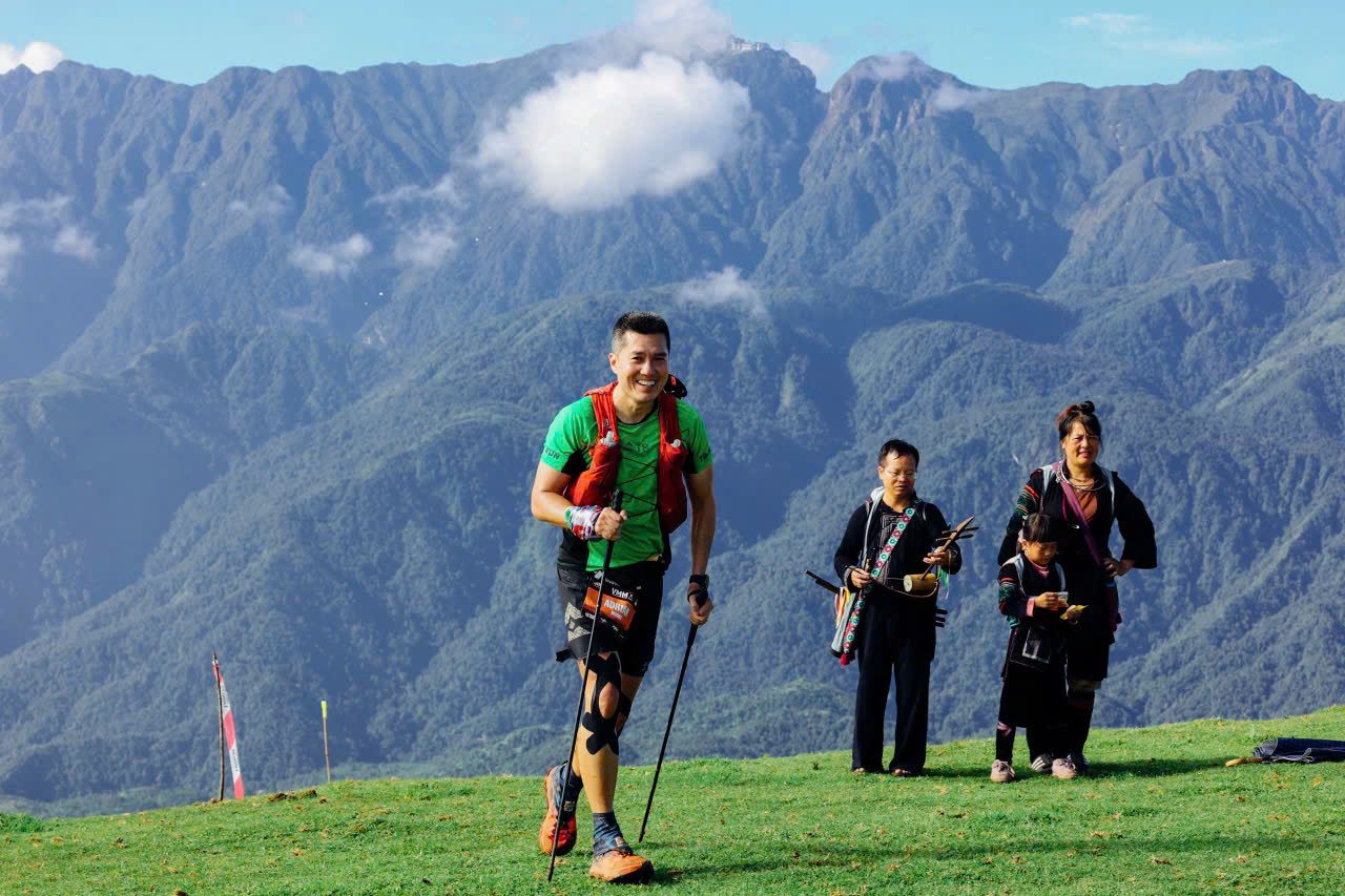 A runner walking uphill with local women in the high mountains near Sa Pa