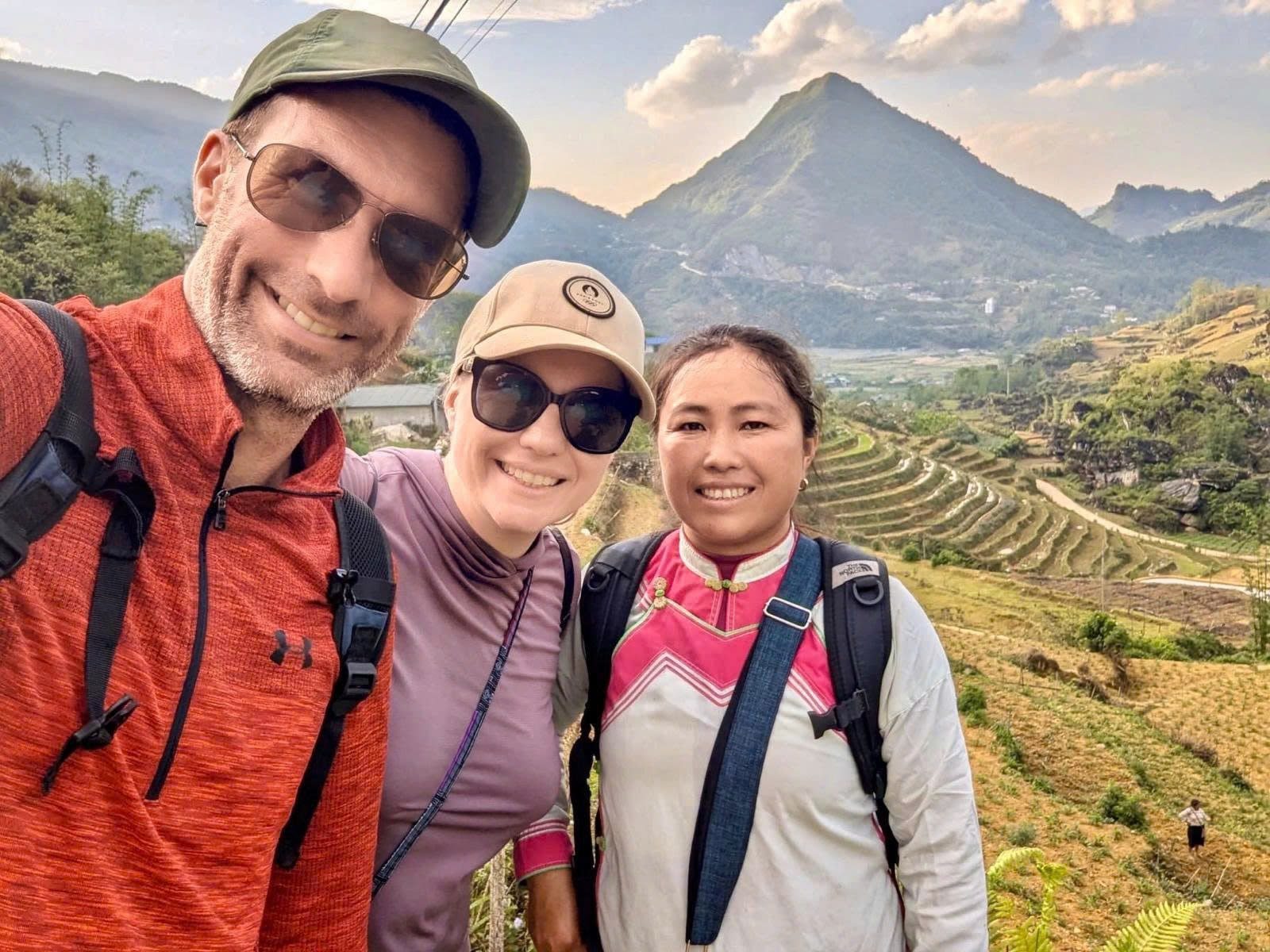 Local guide Pang with guests and terraced mountain fields near Sa Pa